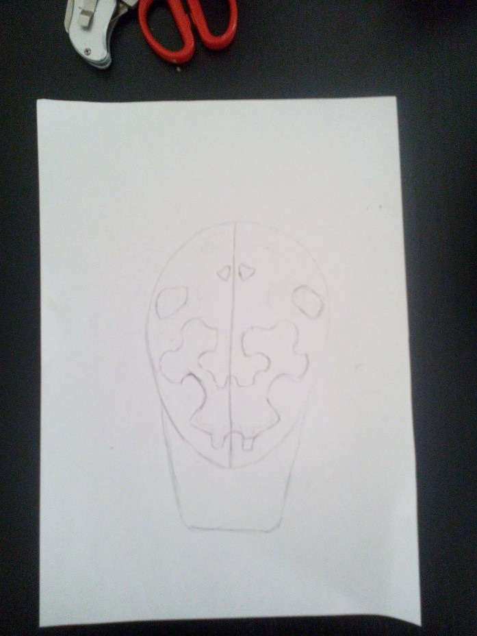 Croquis au crayon du motif de Michel, dessiné dans une forme de masque sur une feuille.